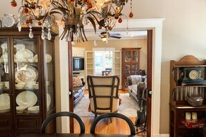 A dining area with a chandelier, a television, and a bookshelf.