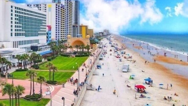 A beachside hotel with a long promenade, palm trees, and a view of the ocean. - 2-Min Walk to Beach, 3 Cars, 3BR Family Escape walkable to Boardwalk (Daytona Beach)