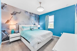 Un dormitorio moderno con una cama blanca, paredes azules y una pared de acento con diseño geométrico.