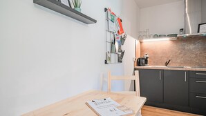 Eine moderne Küche mit einem Holztisch, einer Kaffeemaschine und einem Regal mit einer Pflanze.