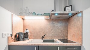 Eine moderne Küche mit eingebautem Herd, einer Spüle und einer Kaffeemaschine.