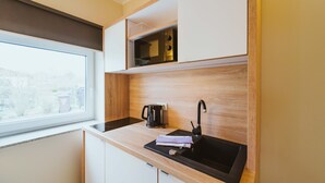 Cuina moderna amb un rentaplat de color negre, una cafetera i una finestra que ofereix vistes a l'exterior.