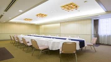 A conference room with a long table, chairs, and ceiling lights.