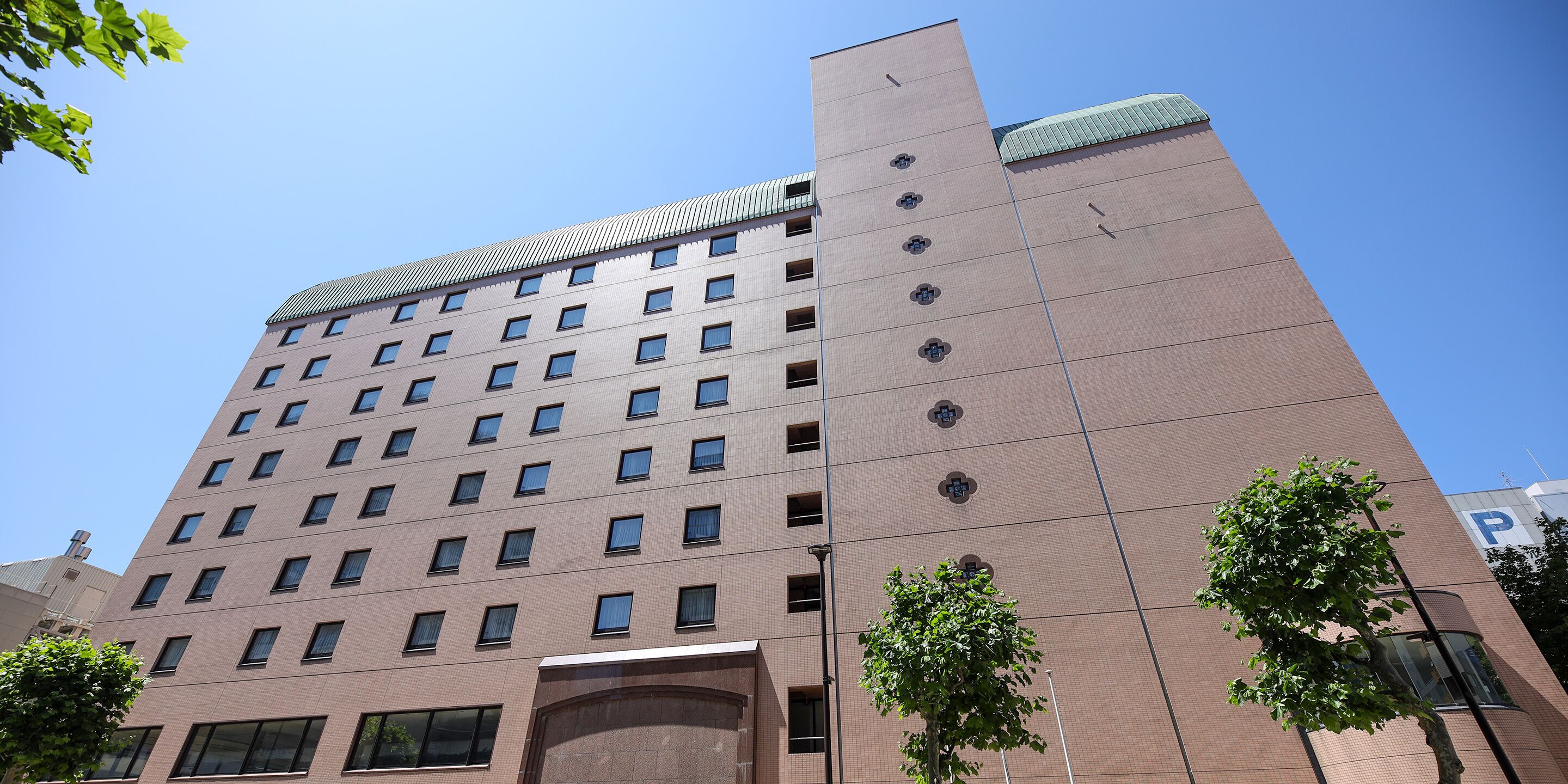 A multi-story building with a modern architectural design, featuring a series of windows and a prominent entrance.