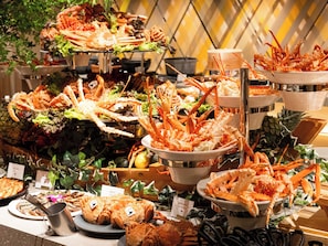 A buffet with various seafood dishes, including crab legs and fish, arranged on multiple serving platters. - Hotel Abest Sapporo (Sapporo)