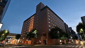 A multi-story hotel with a modern design, featuring a prominent entrance and a series of windows on the facade.