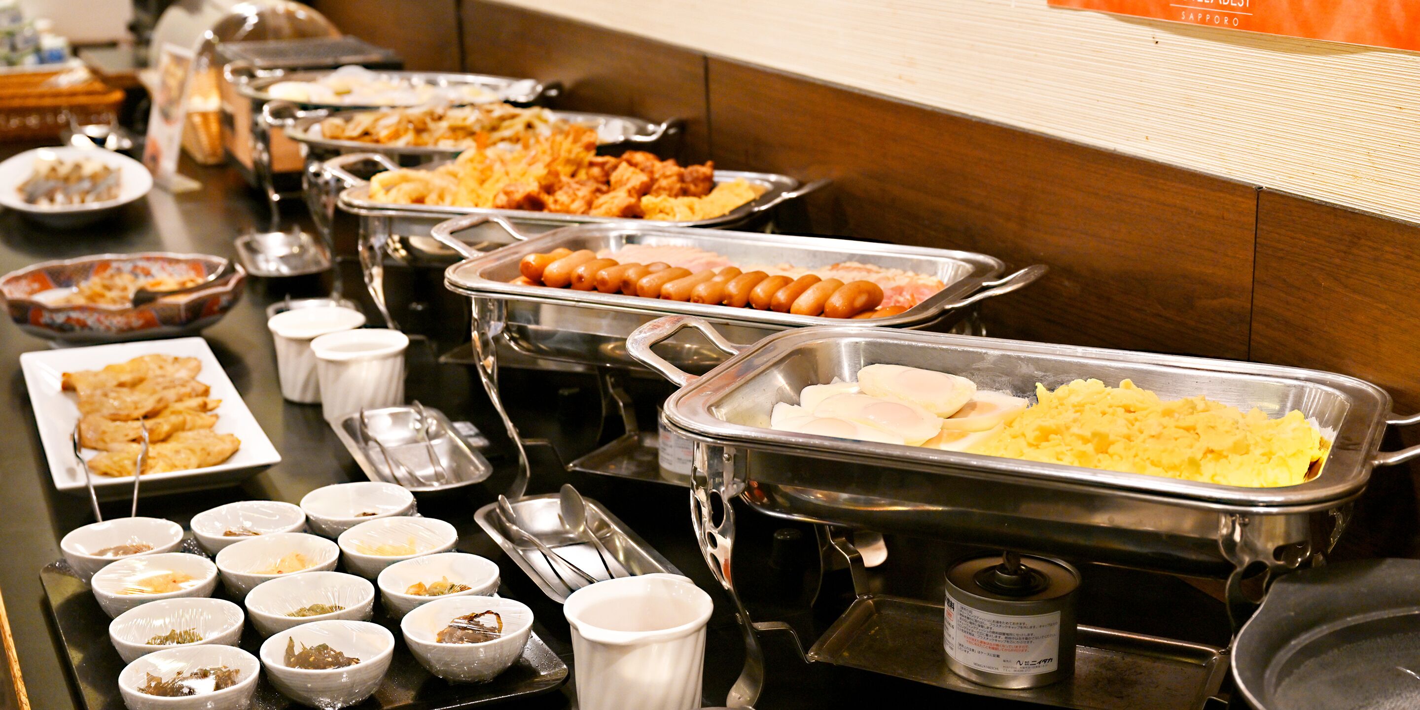 A buffet with various food items and serving utensils.
