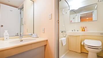 Un baño moderno con lavamanos, espejo, ducha e inodoro.