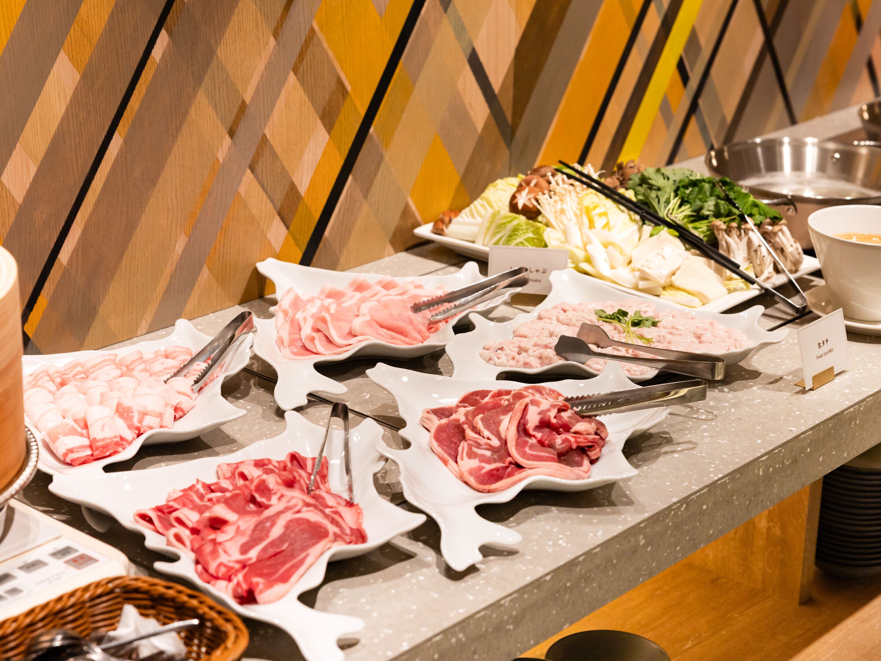 A buffet with various types of meat and vegetables.