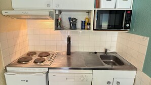 A compact kitchen with a Bosch stove, dishwasher, and microwave. - Cozy 2-room apartment at the foot of the slopes (Les Adrets-Prapoutel)