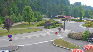 Kreisverkehr mit Haltesignal, Nichtparkplatzschild und Fußgängerüberweg.