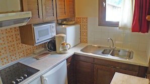 A compact kitchen with a stove, microwave, toaster, and sink. - 4-room duplex with balcony and Wifi in Samoëns for 8 guests (Samoëns)