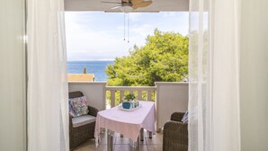 A balcony with a table, chairs, and a ceiling fan. - Pirka - Apt. w. Terrace & sea View,2 min to Beach (Sutivan)