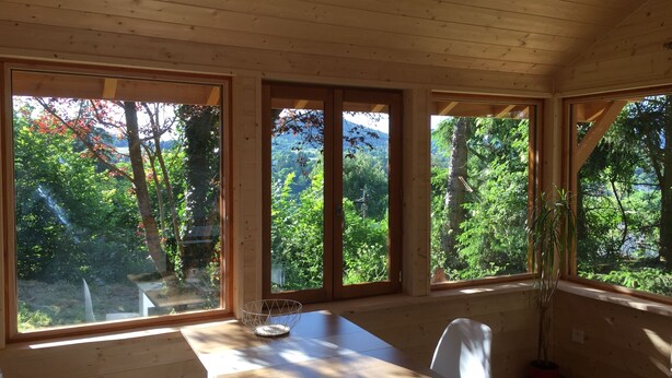 A wooden cabin with large windows offering views of a forested area. - Chalet - Lac Daydat (Aydat)