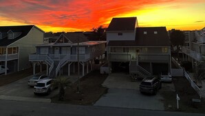 Eine Wohnstraße mit Häusern, blauem Himmel und Sonnenuntergang.