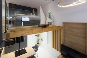 Decoração moderna com estrutura de vigas de madeira, um modelo de veleiro e uma televisão.