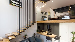 A modern loft-style apartment with a kitchen, dining area, and a loft bedroom with a sailboat model. - Beautiful, Modern Apartment Near the Sea, Croatia (Kastela)