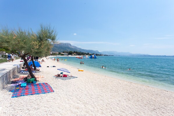 Enjoy a day of leisure by the sea with lounge chairs and umbrellas along the shoreline.