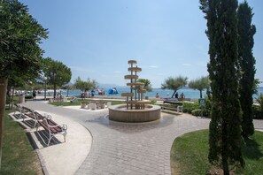 Surround yourself with serenity by the tranquil water feature, complete with a paved walkway and benches for relaxation.