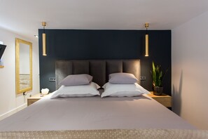 Relax in a serene bedroom with a large bed, tufted headboard, and two bedside tables.