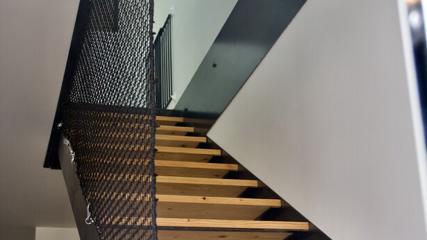 A staircase with wooden steps and a metal railing.