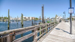 A wooden pier extending over water with a sign indicating no skateboarding and walk bikes allowed. - Surf's Up at Island Breeze of CB (Carolina Beach)