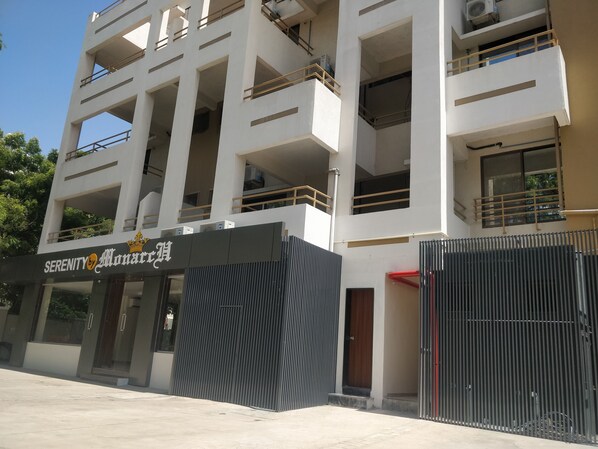 Un immeuble à plusieurs étages doté de balcons, d’une entrée sécurisée et d’une enseigne indiquant « Serenity by Alonarr ».