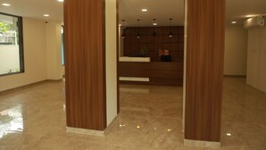 A modern hotel lobby with wooden pillars, a reception desk, and pendant lighting.