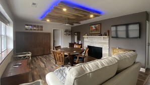 A spacious living room with a wooden ceiling, a fireplace, a dining area, and a sofa. - Parkview at Cataract Falls Lodge.   (Spencer)