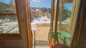 A doorway leading to a snowy outdoor area with a bench and a table. - Mountain Retreat | Ground Floor & Walk to Village (Keystone)