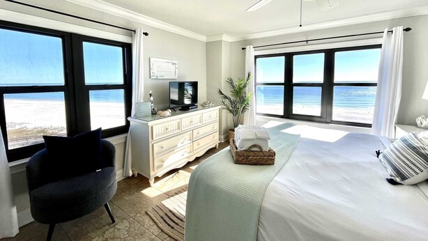 A bedroom with a bed, a desk, a chair, and a view of the beach. - Harbour Place 511 3 Bedroom Condo by RedAwning (Orange Beach)
