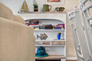 Una sala de estar acogedora con una estantería, un pez decorativo y una taza azul.