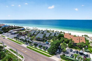 Zona residencial costera con acceso a la playa, un estacionamiento y una carretera con flechas direccionales.