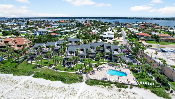 Un resort con varias construcciones, piscina y acceso a la playa.