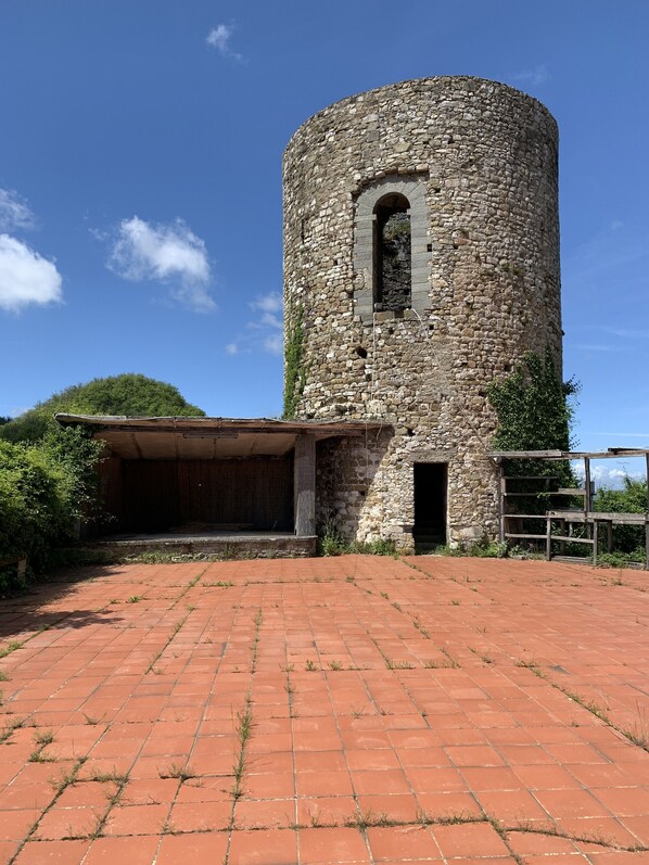 A stone tower with a small arched window and a covered entrance.