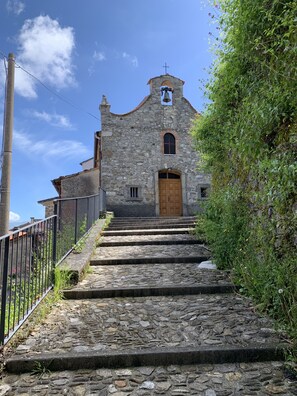 A stone church with a bell tower and a wooden door.