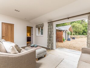 A spacious living room with a large sliding glass door leading to an outdoor area. - Delightful 2Bed Lodge in Downland Village - Pass the Keys (Chichester)