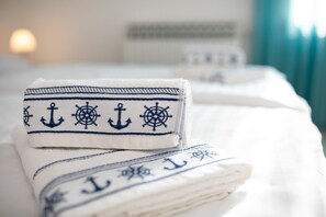 Neatly folded towels with nautical designs on a bed. - Apartment Tonica 2 with balcony (Bogovici)