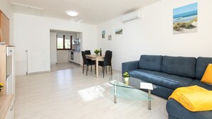 Eine moderne Wohnung mit Essbereich, einer Couch und einem Glastisch.