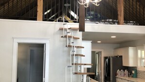 A modern interior with a wooden staircase, a chandelier, and a kitchen area. - MT dreams create memories that last a lifetime ❄️ Winter Land ☀️ Summer serenity (Marion)