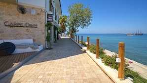 A coastal walkway with a stone wall labeled "CARPE DIEM" and a wooden bench. - Carpe Diem Boutique Hotel - Adults Only (Manavgat)