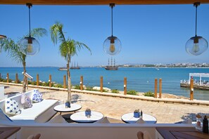 A seaside terrace with lounge chairs, tables, and hanging light fixtures overlooking the sea. - Carpe Diem Boutique Hotel - Adults Only (Manavgat)