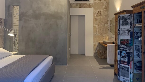 A modern bedroom with a bed, a desk, and a wardrobe. - Casa Lunya (siracusa)