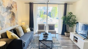 A modern living room with a sofa, armchairs, a coffee table, and a TV. - LUXURY THE YATCH 301- FREE PARKING AND WIFI (Aventura)