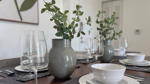 A dining table set with clear glassware, white bowls, and grey placemats. - LUXURY THE YATCH 301- FREE PARKING AND WIFI (Aventura)