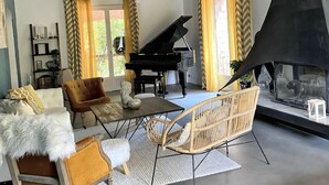 A spacious living room with a grand piano, a fireplace, and a chandelier. - LE MAS Calisto (TRANS EN PROVENCE)