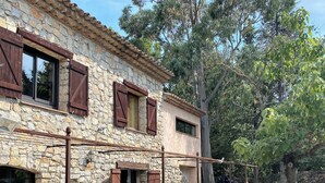A stone building with wooden shutters, a stone staircase, and potted plants. - LE MAS Calisto (TRANS EN PROVENCE)