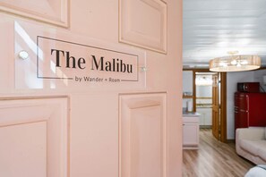 A door with a sign that reads 'The Malibu by Wander + Roam.'