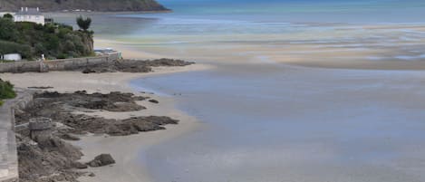Una playa cerca, sillas reclinables de playa, toallas de playa