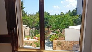 Una habitación con un ventanal grande que da a un jardín. Hay dos comederos para mascotas en el suelo.
